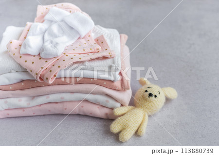 Stack of Baby bodysuits on a grey background. Stack of Baby bodysuits on a grey background. 113880739