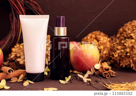 moisturizing cream pink tube bottle with black screw cap, brown cosmetic spray bottle, apples, cinnamon, dried flower. Body skincare, shampoo, hair conditioner packaging mockup in autumn composition moisturizing cream pink tube bottle with black screw cap, brown cosmetic spray bottle, apples, cinnamon, dried flower. Body skincare, shampoo, hair conditioner packaging mockup in autumn composition 113883102