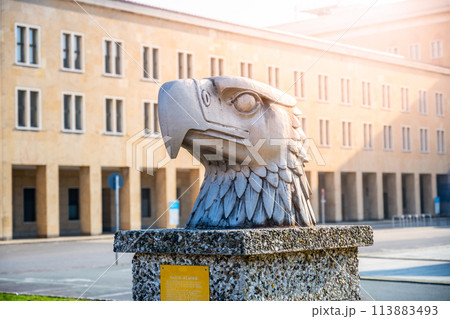 A detailed sculpture of an eagles head by Wilhelm Lemke, set against the backdrop of terminal building of Tempelhof Airport. Eagle Square, Berlin, Germany 113883493