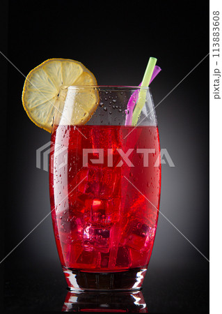 glass with red drink with ice 113883608