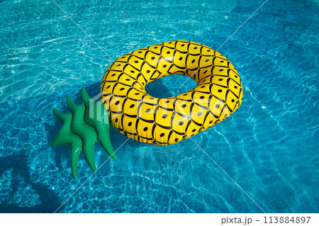 Yellow rubber ring floating in a blue pond on a summer day Yellow rubber ring floating in a blue pond on a summer day 113884897