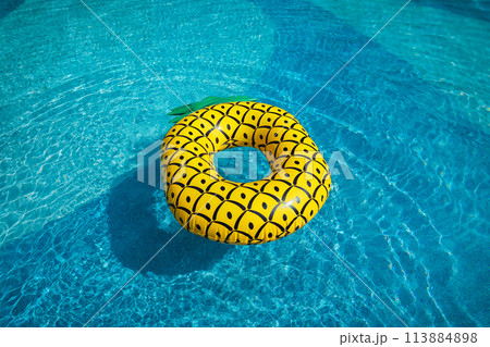 Yellow rubber ring floating in a blue pond on a summer day 113884898