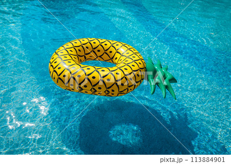 Yellow rubber ring floating in a blue pond on a summer day Yellow rubber ring floating in a blue pond on a summer day 113884901