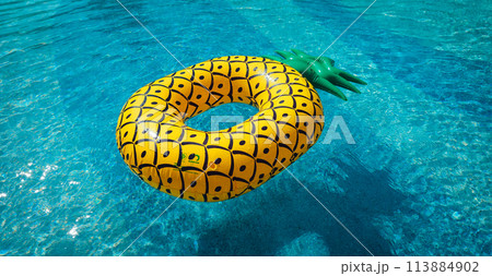 Yellow rubber ring floating in a blue pond on a summer day 113884902