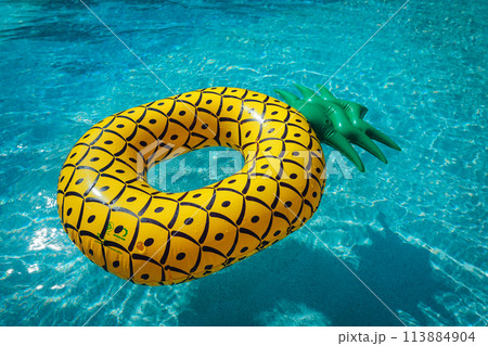 Yellow rubber ring floating in a blue pond on a summer day Yellow rubber ring floating in a blue pond on a summer day 113884904