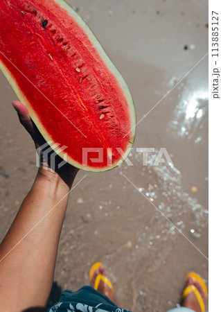 red watermelon in hand at sea red watermelon in hand at sea 113885127