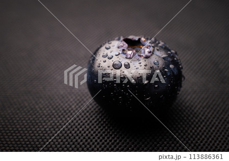 One blueberry covered with water drops on black background. Very detailed macro shoot with copy space 113886361