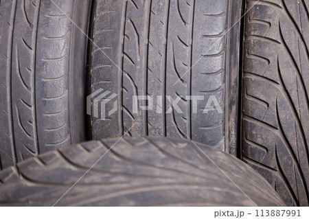 Automobile composition made up stack of tires and wheel with shiny disc in a car service before seasonal replacement or after breaking through. 113887991
