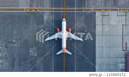 Top down view on commercial airplane docking in terminal in the parking lot of the airport apron, waiting for services maintenance, refilling fuel services after airspace lock down 113889152