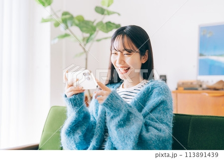 スマホでゲームをする女性 スマホでゲームをする女性 113891439