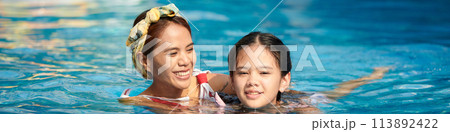 Header with happy mother and teenage daughter swimming in pool together 113892422