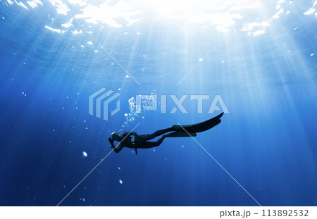 Freediver Swimming in Deep Sea With Sunrays. 113892532