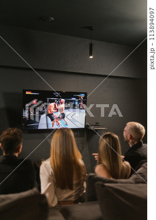 Couples unwind during evening watching wrestling on television Couples unwind during evening watching wrestling on television 113894097