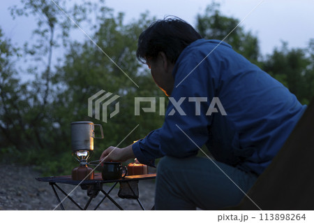 夕暮れのソロキャンプ を楽しむ男性 113898264