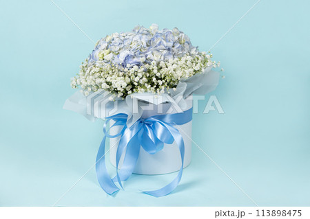Bouquet of flowers made of hydrangeas and gypsophila in a white box with a bow Bouquet of flowers made of hydrangeas and gypsophila in a white box with a bow 113898475