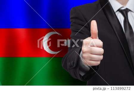 Azerbaijani concept. Businessman showing thumb up on the background of flag of Azerbaijan 113899272