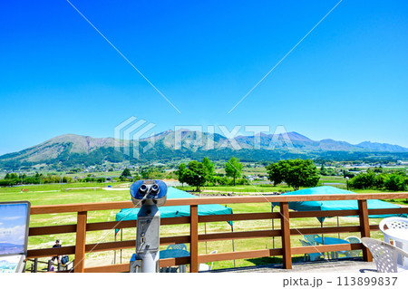 望遠鏡と阿蘇山　うららかな春空を背景に道の駅　展望台から観える風景　「道の駅 あそ望の郷くぎの」 113899837