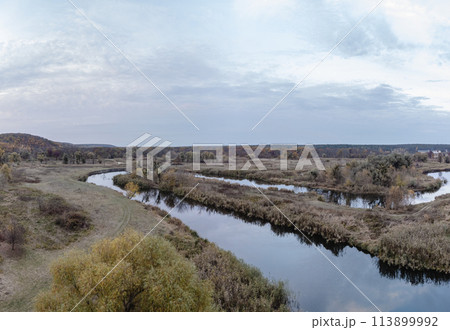 Rural river curve in autumn valley Rural river curve in autumn valley 113899992