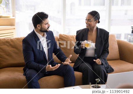 Two multiethnic business man and woman discussing work tasks Two multiethnic business man and woman discussing work tasks 113901492
