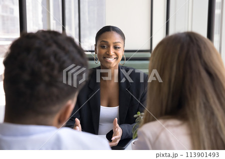 Happy African American real estate consultant meeting with young couple Happy African American real estate consultant meeting with young couple 113901493