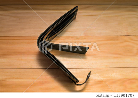 Men's wallet made of black leather on light wood, Shooting for the catalog Men's wallet made of black leather on light wood, Shooting for the catalog 113901707