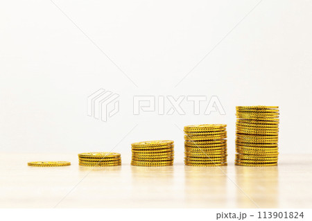 机に積み上げた金貨 113901824