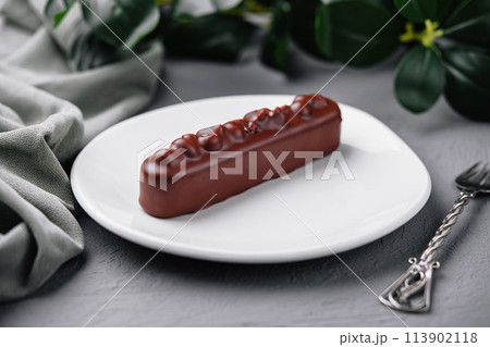 Elegant chocolate bar dessert on white plate 113902118