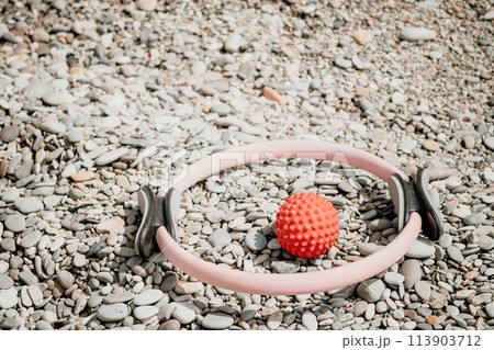 Pilates magic ring and rubber band on yoga mat near sea. Female fitness yoga concept. Healthy lifestyle harmony and meditation. 113903712