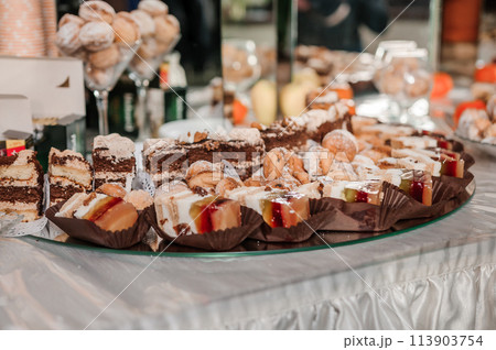 Sweet cakes at a wedding banquet. Catering, sweet festive buffet. Candy bar Sweet cakes at a wedding banquet. Catering, sweet festive buffet. Candy bar 113903754