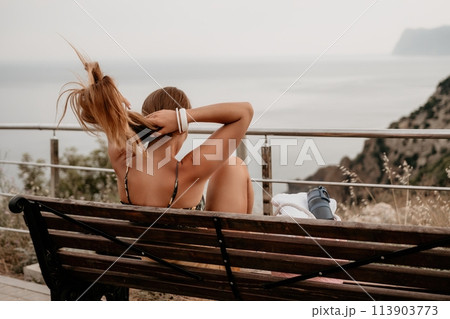 Woman travel sea. Happy tourist enjoy taking picture outdoors for memories. Woman traveler looks at the edge of the cliff on the sea bay of mountains, sharing travel adventure journey Woman travel sea. Happy tourist enjoy taking picture outdoors for memories. Woman traveler looks at the edge of the cliff on the sea bay of mountains, sharing travel adventure journey 113903773