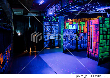 Labyrinth in neon light. Laser tag, paintball in the maze Labyrinth in neon light. Laser tag, paintball in the maze 113904620
