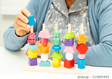 Alzheimer disease AD, Asian elderly woman patient suffering from dementia learn practical motor skills rehabilitation. 113905445