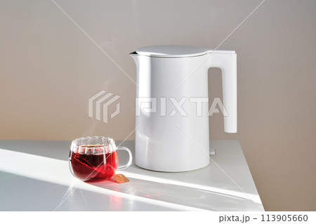 Glass mug with hot black tea on the table. 113905660