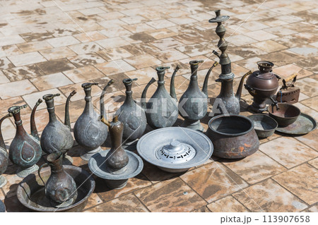 Ancient jugs and other dishes for sale stand on the pavement Ancient jugs and other dishes for sale stand on the pavement 113907658