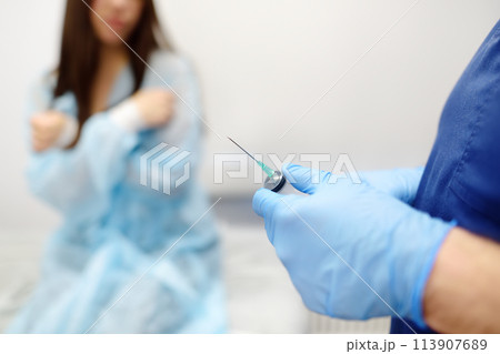 Mammalogist doctor is preparing to examine woman breasts and lymph nodes using ultrasound for diagnosis of breast cancer during appointment. Oncologist holding biopsy slide glasses and syringe. Mammalogist doctor is preparing to examine woman breasts and lymph nodes using ultrasound for diagnosis of breast cancer during appointment. Oncologist holding biopsy slide glasses and syringe. 113907689