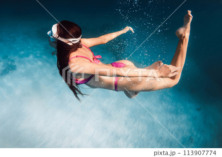Woman with ideal body snorkeling in blue sea. Swimming underwater in ocean on Oahu Woman with ideal body snorkeling in blue sea. Swimming underwater in ocean on Oahu 113907774