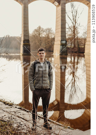Youthful Exploration: 17-Year-Old Teen in Stylish Jacket by Neckar River and Historic Bridge in Bietigheim-Bissingen, Germany Youthful Exploration: 17-Year-Old Teen in Stylish Jacket by Neckar River and Historic Bridge in Bietigheim-Bissingen, Germany 113908519