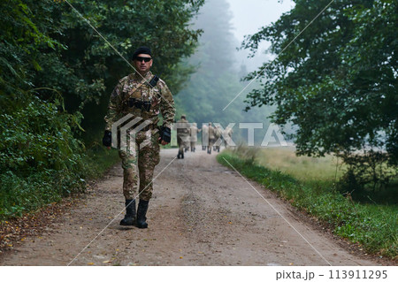 A group of elite soldiers leads captives through a military camp, showcasing a tense atmosphere of detention and security operations 113911295