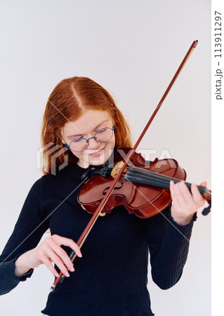 Stunning Redhead Musician Poses with Violin in Captivating Portrait Stunning Redhead Musician Poses with Violin in Captivating Portrait 113911297