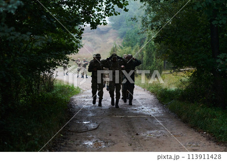 A group of elite soldiers leads captives through a military camp, showcasing a tense atmosphere of detention and security operations 113911428
