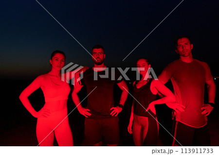 Diverse Athletes Unwind: Post-Marathon Rest Under Red Nighttime Glow. Diverse Athletes Unwind: Post-Marathon Rest Under Red Nighttime Glow. 113911733