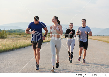 A group of friends maintains a healthy lifestyle by running outdoors on a sunny day, bonding over fitness and enjoying the energizing effects of exercise and nature 113911894