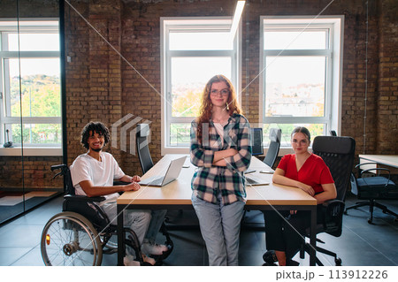 A diverse group of business professionals collaborates in a modern startup coworking center, utilizing a mix of paper-based and technological tools such as mobile phones and computers A diverse group of business professionals collaborates in a modern startup coworking center, utilizing a mix of paper-based and technological tools such as mobile phones and computers 113912226