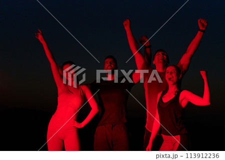 Late-Night Triumph: Group of Friends Celebrate Marathon Success. 113912236