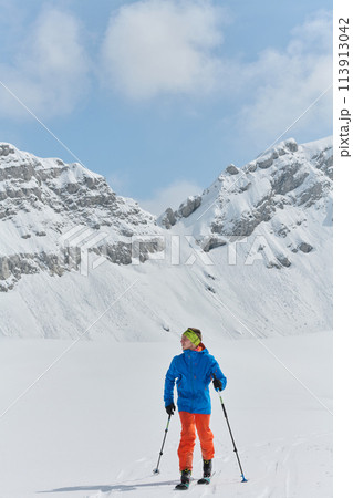 A Skier Scales a Treacherous Alpine Peak 113913042