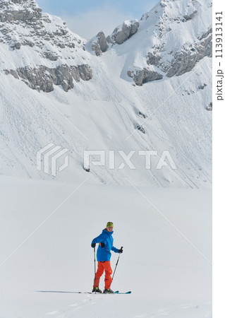 A Skier Scales a Treacherous Alpine Peak 113913141