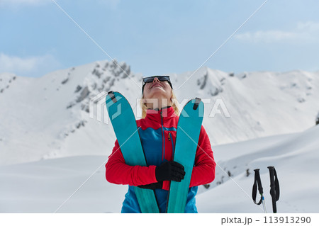 A professional woman skier rejoices after successfully climbing the snowy peaks of the Alps A professional woman skier rejoices after successfully climbing the snowy peaks of the Alps 113913290