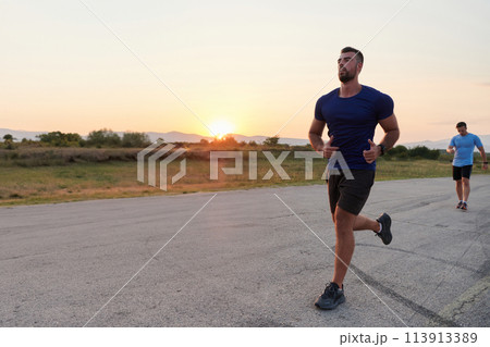 A diverse group of runners trains together at sunset. A diverse group of runners trains together at sunset. 113913389