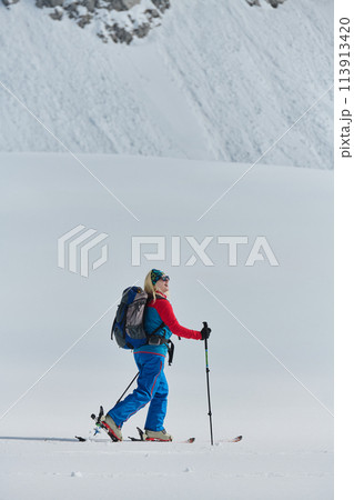 A Female Mountaineer Ascends the Alps with Backcountry Gear 113913420