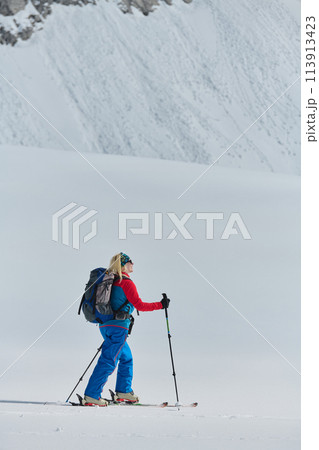 A Female Mountaineer Ascends the Alps with Backcountry Gear 113913423